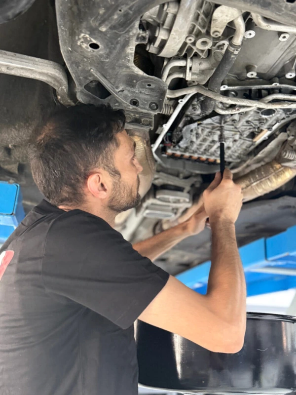 Mechanic working on a vehicle from underneath the lift