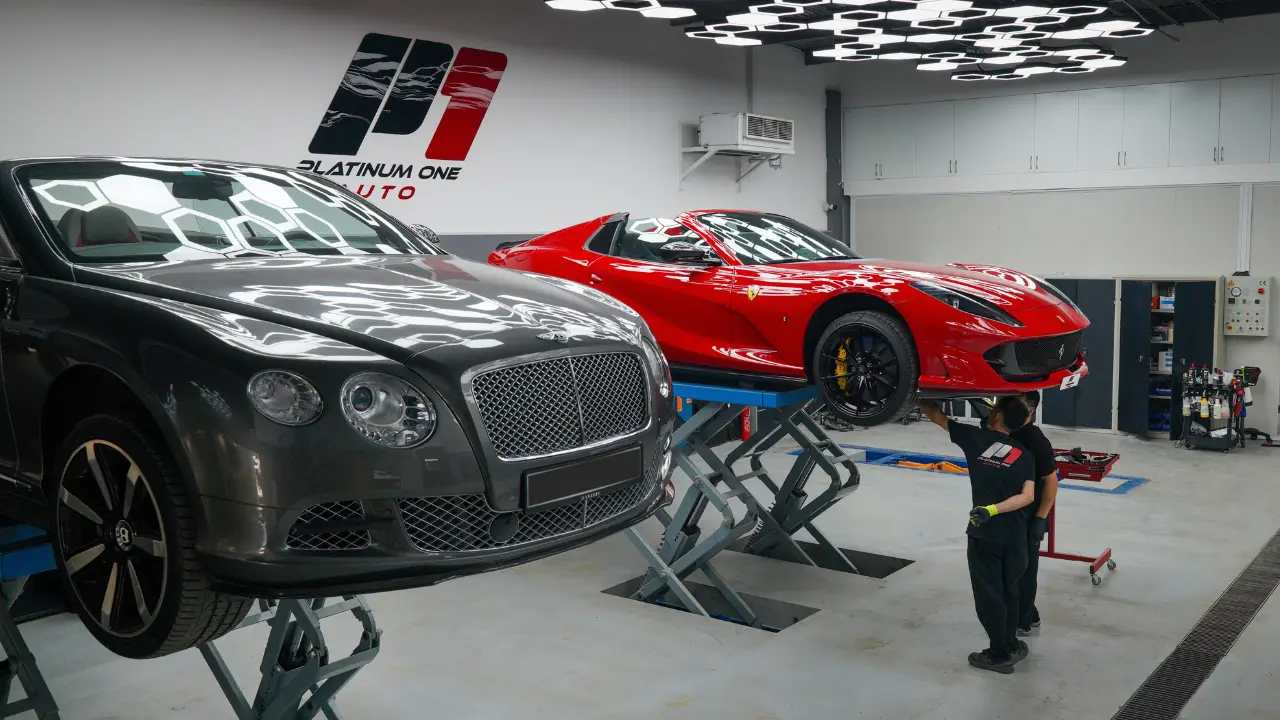 Bentley Continental GT and red Ferrari 812 GTS on lifts in the service bay at Platinum One Auto in Dubai